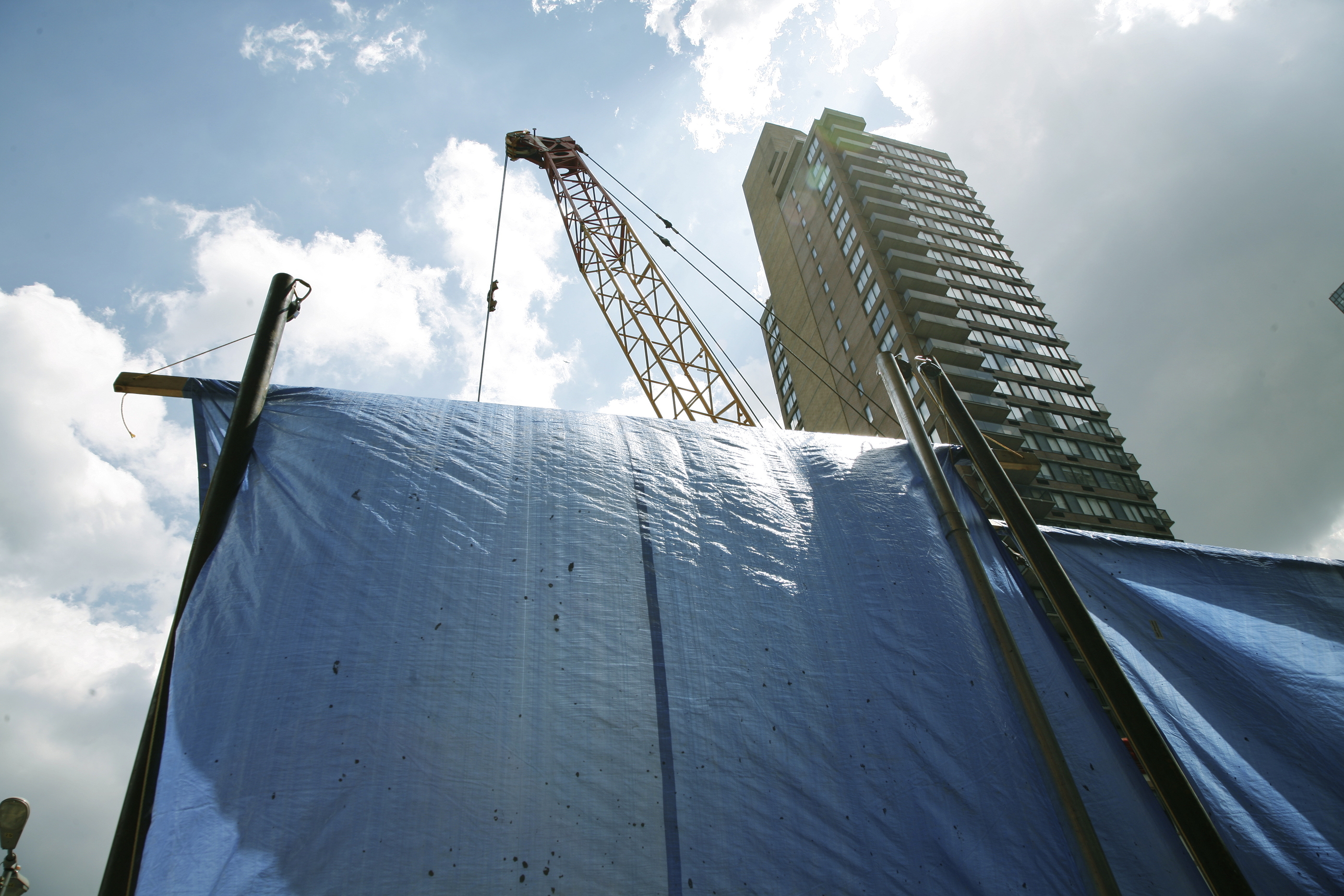 building under construction with blue tarp in front